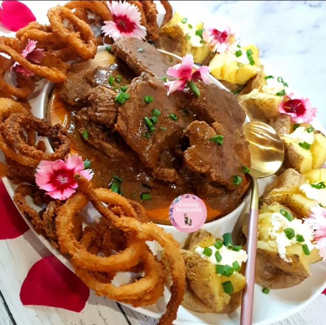 Spur Style Steak Served With Onion Rings And Spuds